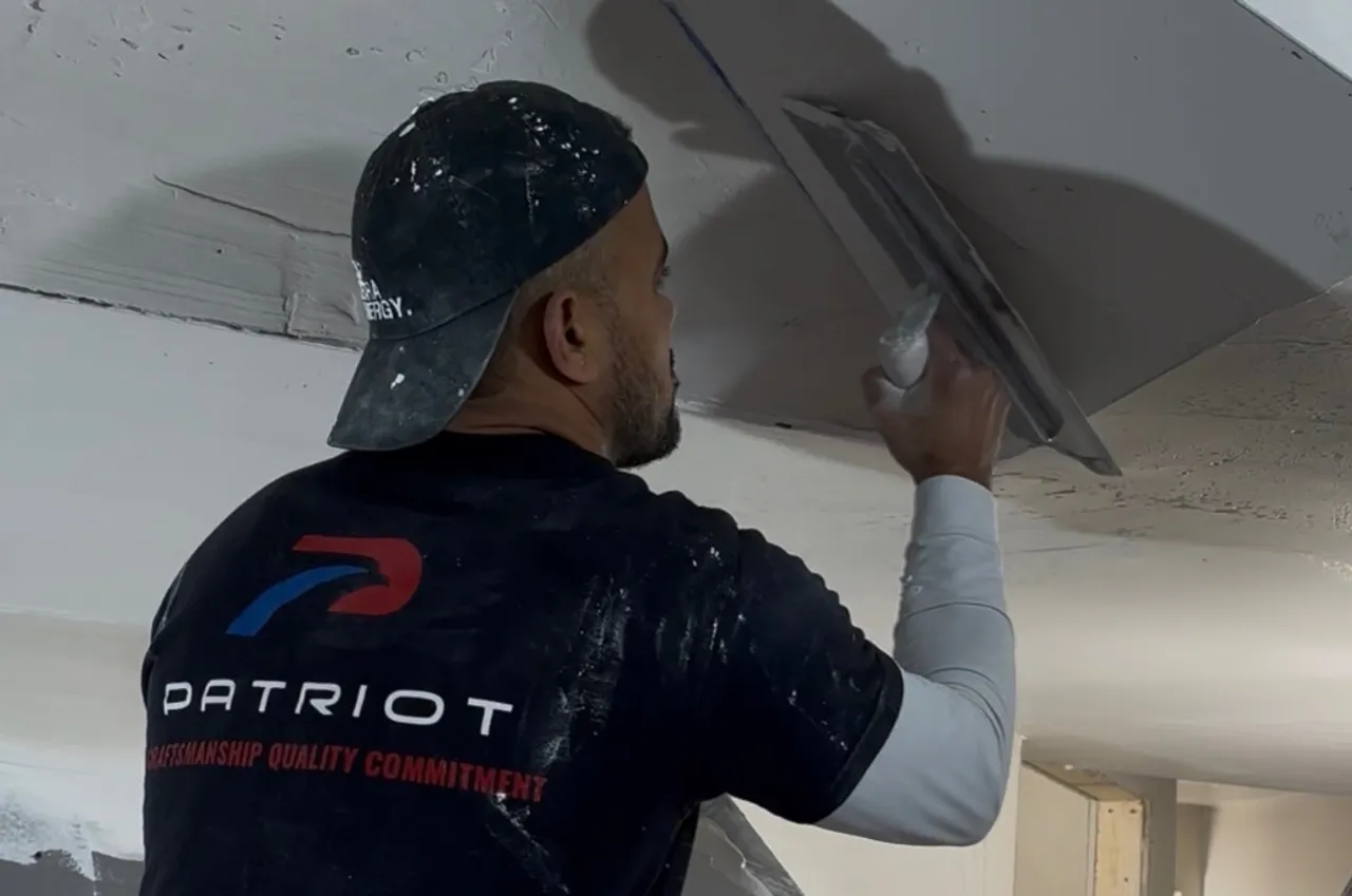 Patriot Plastering worker applying plaster to ceiling