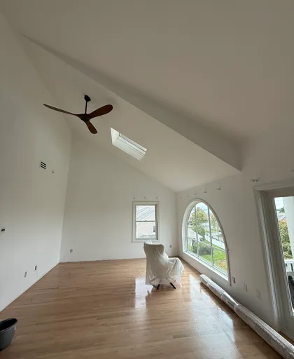 plastered room with arched window and vaulted ceiling