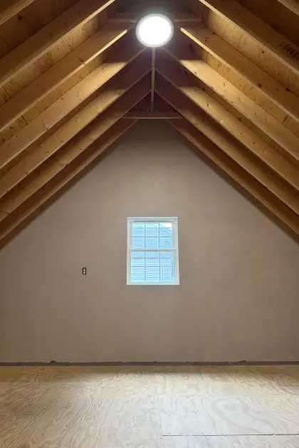 Plastered attic gable wall beneath exposed timber rafters