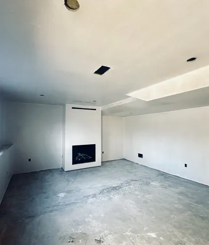 basement living space with fireplace drywall
