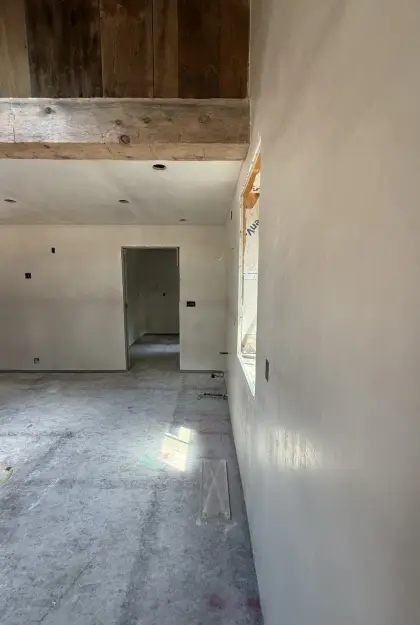 Smooth plaster wall finish in a room with exposed timber beams