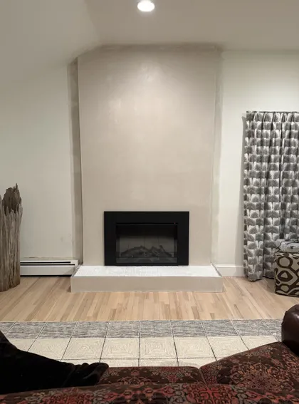 finished living room with plastered fireplace surround