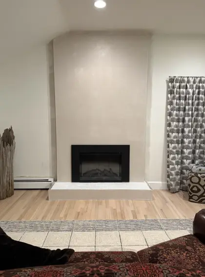 finished living room with plastered fireplace surround
