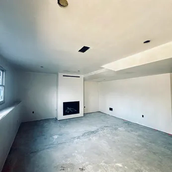 new construction room with fireplace and beam ceiling