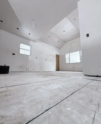 new construction great room with vaulted ceiling plastering