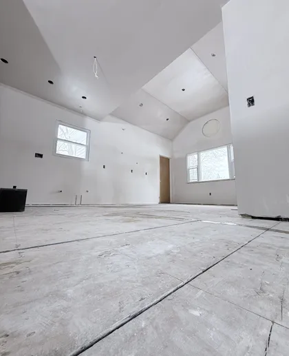 new construction great room with vaulted ceiling plastering