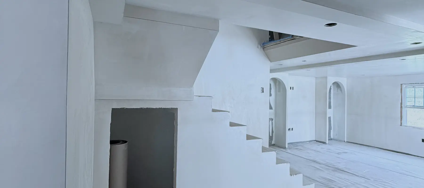 Open-plan home with smooth newly plastered walls and staircase