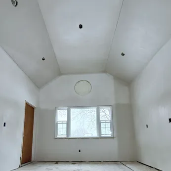 plastered vaulted ceiling with round window
