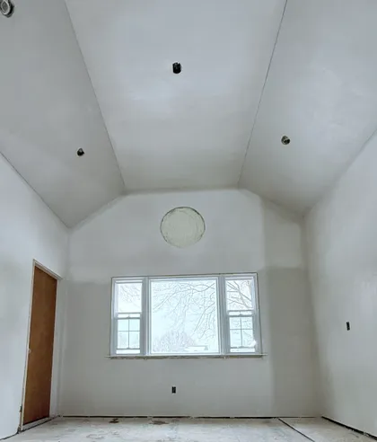 plastered vaulted ceiling with round window