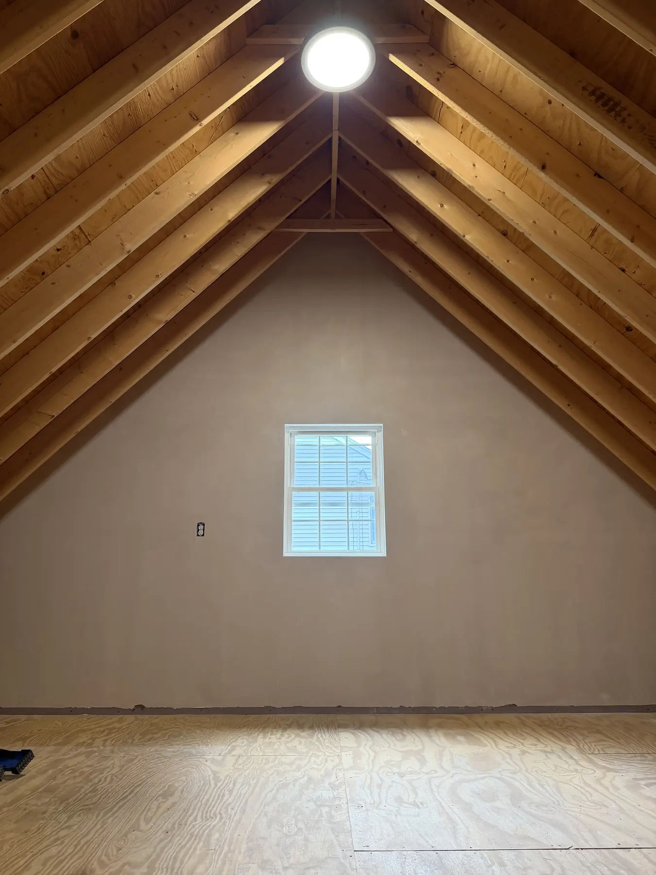 Plastered attic gable wall beneath exposed timber rafters