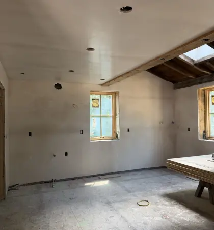 New plaster walls and ceiling beside exposed timber beams