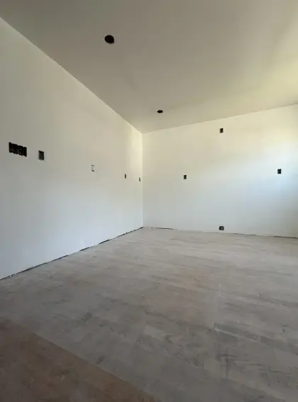 Freshly plastered walls and ceiling in a bright unfinished room