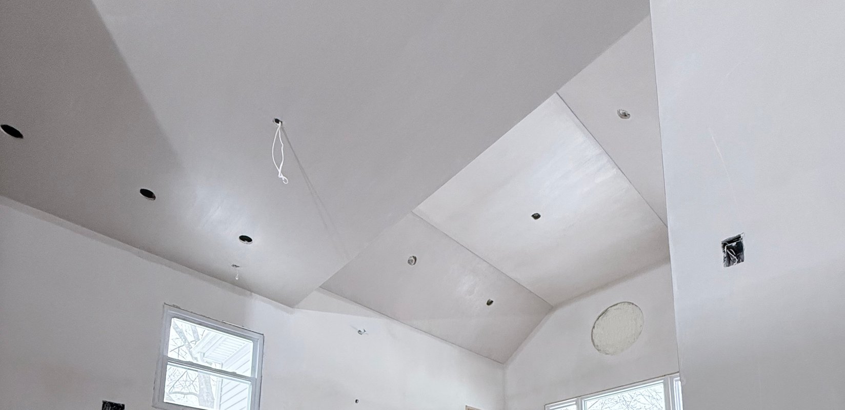 Smooth plaster finish across a custom vaulted ceiling and walls