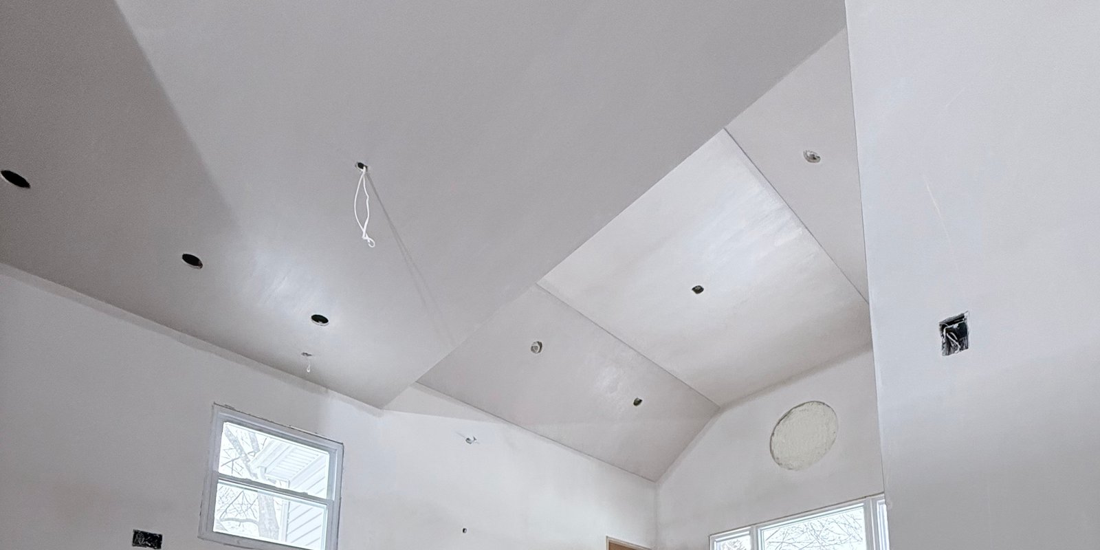 Smooth plaster finish across a custom vaulted ceiling and walls